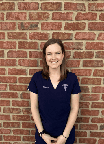 Dr. Taylor Dr. Taylor standing outside smiling in navy scrubs