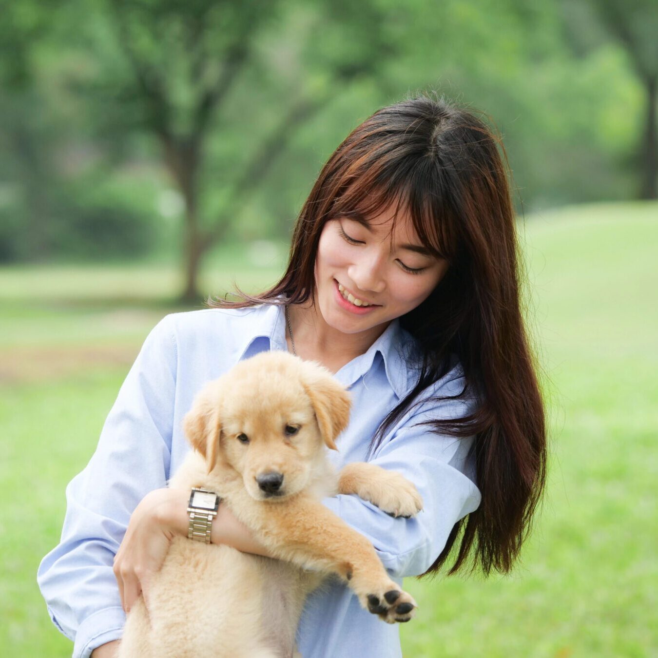 smiling young woman holding a puppy